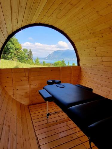 a sauna with a round window in a wooden room at Les Ô d'Annecy in Saint-Jorioz