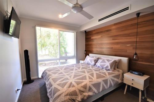 a bedroom with a large bed with a wooden headboard at Esplanade Sophistication Close To Town And Inlet Beach in Inverloch