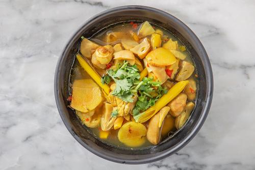 a bowl of soup with oranges and other vegetables at FOODOTEL in Bangkok