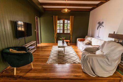 un soggiorno con divano e 2 sedie di Magnifique villa créole VILLA TI BOUT BOIS avec cheminée au tevelave a Les Avirons