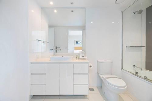 a white bathroom with a sink and a toilet at Spectacular 19th Floor Apartment in Heart of Surfers Paradise in Gold Coast
