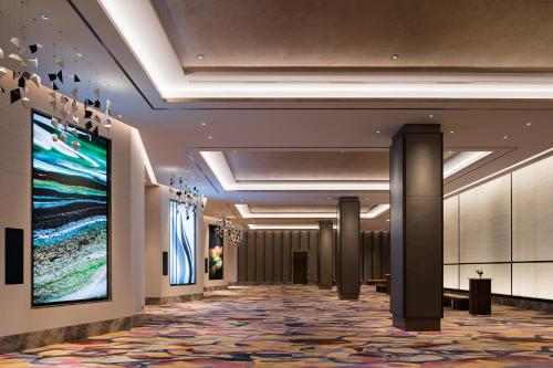 a hallway of a hotel with a large painting on the wall at MGM Shanghai West Bund in Shanghai