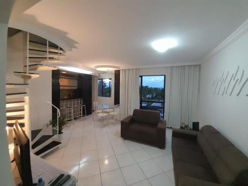 a living room with a couch and a chair at dúplex beira-mar in Maceió