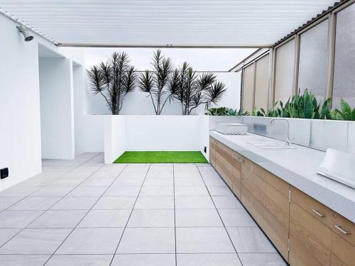 uma casa de banho com plantas no meio de um quarto em New Modern apartment next to Westfield Chermside em Brisbane