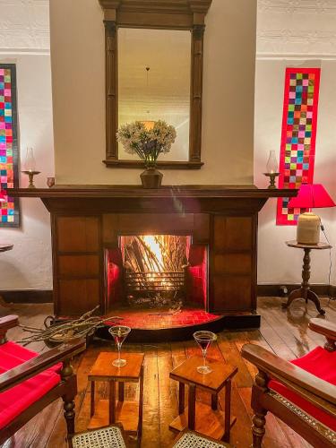a living room with a fire place in the middle at Scottish Planter Bungalow- Thema Collection in Nuwara Eliya