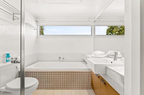 ein Badezimmer mit einer Badewanne, einem Waschbecken und einem WC in der Unterkunft Bayvista at Silverwater in San Remo