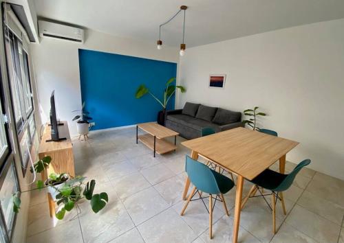 sala de estar con mesa y sofá en Departamento con terraza, parrilla y piscina en Buenos Aires