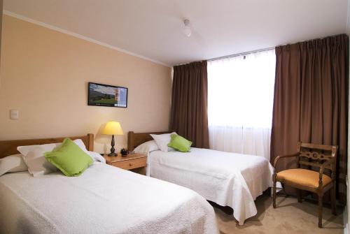um quarto de hotel com duas camas e uma janela em Vegas Apartamentos em Santiago