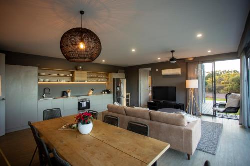 a living room with a table and a couch at Zambezi Lodge, Down South Luxe Retreat in Wilyabrup