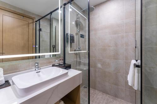 W łazience znajduje się umywalka i prysznic. w obiekcie Joy Fall Hotel w mieście Jiaoxian