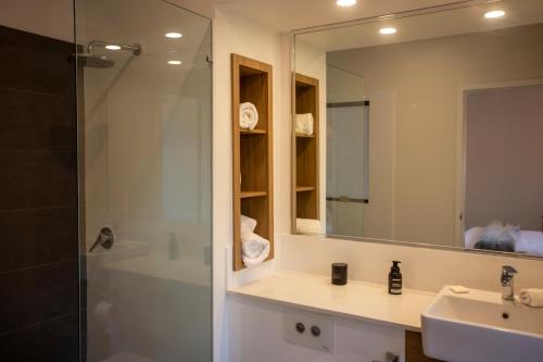 a bathroom with a shower and a sink and a mirror at The WABi Cabin - Perfect Couples Retreat in Wilyabrup