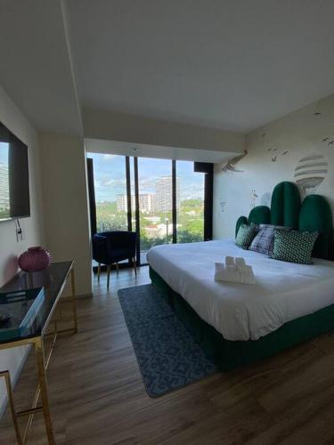 a bedroom with a large bed with a green headboard at Departamento Royal 3H-96 in Guadalajara