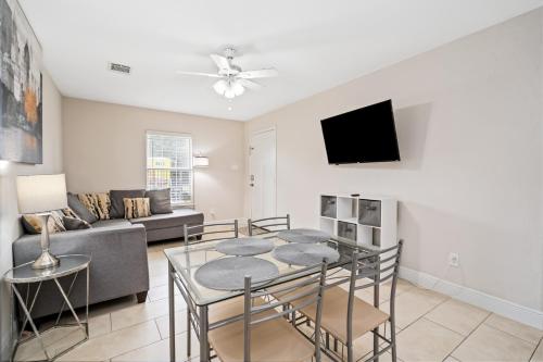 a living room with a table and a couch at Opulent, Luxurious & Modern APT 7 Min From TX Med Center in Houston