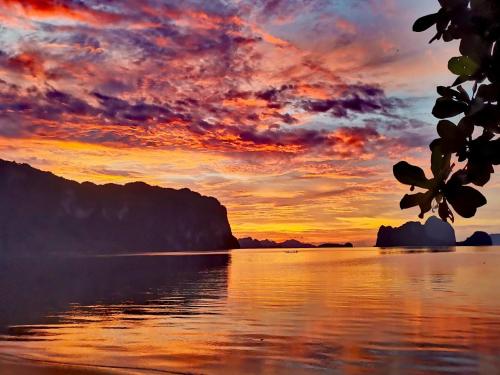 a sunset over a body of water at El Nido Beach Camp in Manlalec