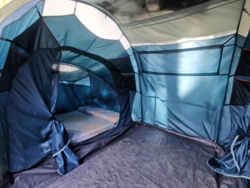 uma tenda azul com uma cama em El Nido Beach Camp 