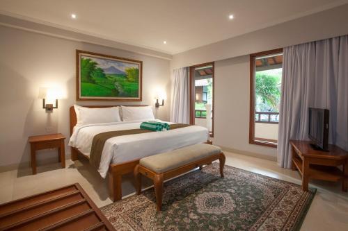 a bedroom with a large bed and a television at Peninsula Beach Resort in Nusa Dua