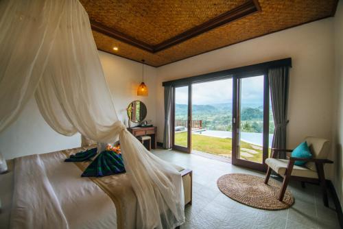 a bedroom with a bed and a window with a view at Patal Kikian Villa in Sidemen