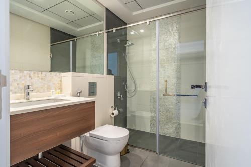 a bathroom with a shower and a toilet and a sink at Primestay - 1BR in Prime Views Al Meydan in Dubai