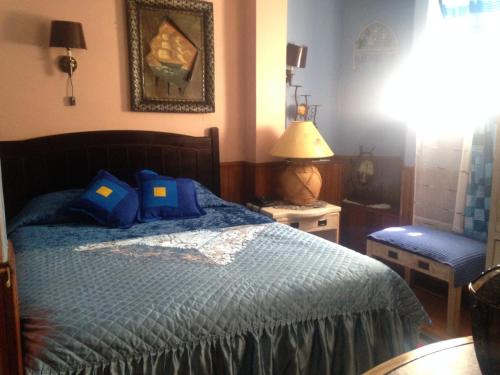a bedroom with a bed with a blue comforter at Hotel La Castellana in Santiago