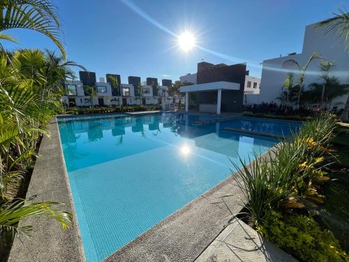 a large swimming pool in a resort with palm trees at Casa vacacional familiar in Naranjo