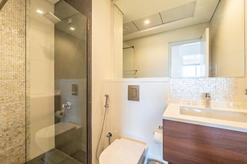 a bathroom with a shower and a toilet and a sink at Primestay - Prime Views 1BR in Al Meydan in Dubai