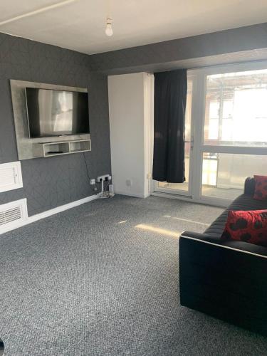 ein Wohnzimmer mit einem Sofa und einem Flachbild-TV in der Unterkunft City View apartments in London