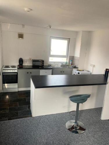 a kitchen with a blue stool in the middle of it at City View apartments in London