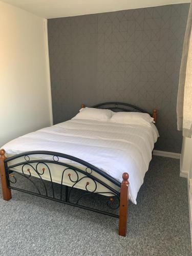 sypialnia z łóżkiem z białą pościelą i ścianą w obiekcie City View apartments w Londynie