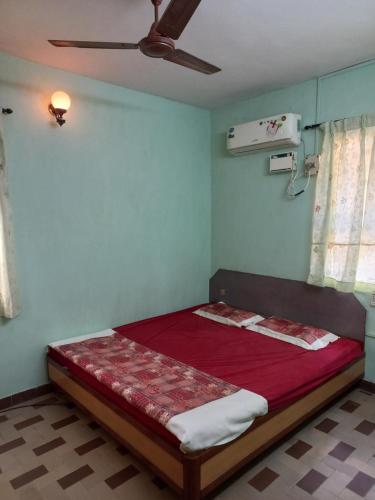 Cama en habitación con ventilador de techo en 2 Bhk Holiday home near Panjim city & Beaches, en Panaji