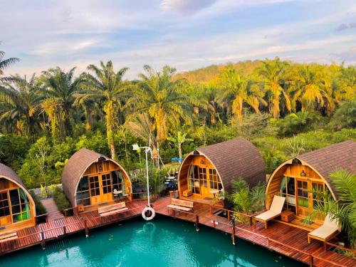 a resort with a pool and palm trees at Plaiphu Pool Villas in Phangnga