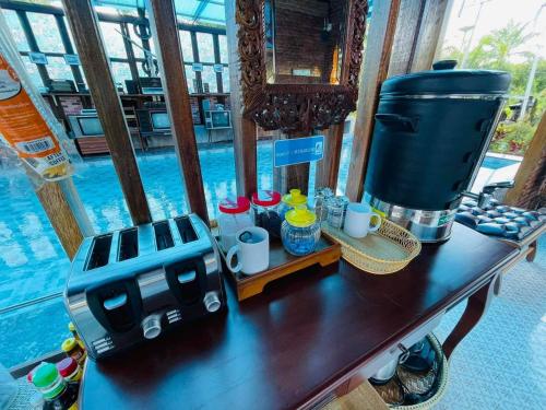 攀牙灣的住宿－Plaiphu Pool Villas，桌边桌边的桌子上配有咖啡壶