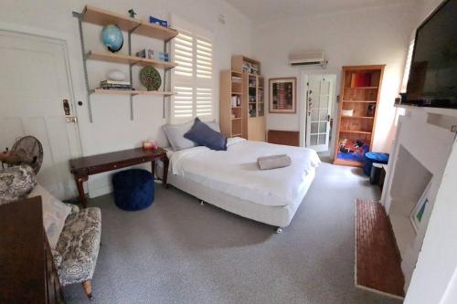 1 dormitorio con cama, mesa y sofá en Wonga - A secluded oasis in the heart of Parkes, en Parkes