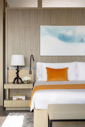 a bedroom with a large bed with an orange pillow at MGM Shanghai West Bund in Shanghai