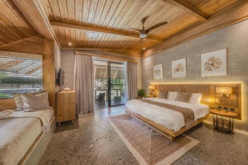 1 dormitorio con 2 camas y techo de madera en Manami Resort, 