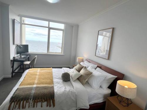 a bedroom with a bed and a desk and a window at Amzing Ocean View Spacious Three Bedrooms Apartment Port Melbourne in Melbourne