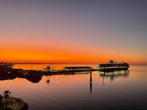a sunset over a body of water with a dock at Amzing Ocean View Spacious Three Bedrooms Apartment Port Melbourne in Melbourne