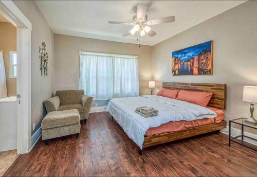 a bedroom with a bed and a chair and a ceiling fan at 2 King Beds! Fantastic Stylish Bungalow home! in Fresno
