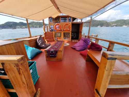 a boat with benches and pillows on the deck at Family Labuan Bajo in Labuan Bajo
