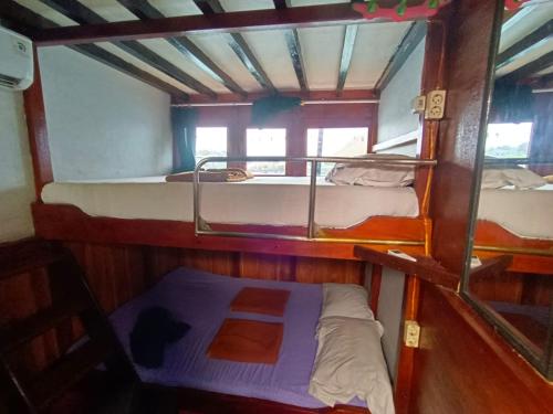 a room with three bunk beds in a boat at Family Labuan Bajo in Labuan Bajo