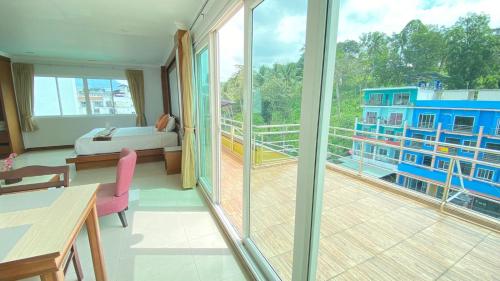 a room with a balcony with a bed and a bedroom at Sukcheewa Residence Phuket in Patong Beach