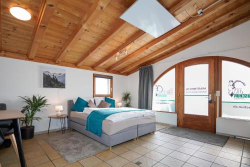 a bedroom with a bed and a wooden ceiling at Solution-Grischun, Parkplatz - Küche- Wäschetrokner- Kaffee, Tee in Flims