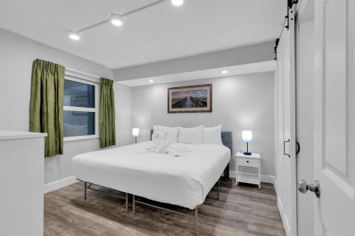 a white bedroom with a large bed and a window at Oceanfront Atlantica 2BR Condo w Balcony in Myrtle Beach