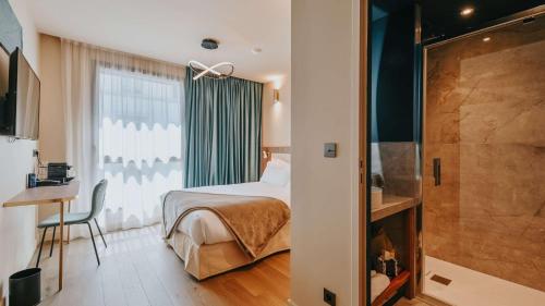 a hotel room with a bed and a shower at Keystone Hôtel & Spa in Lyon