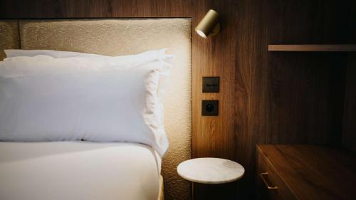 a bedroom with a white bed and a night stand at Keystone Hôtel & Spa in Lyon
