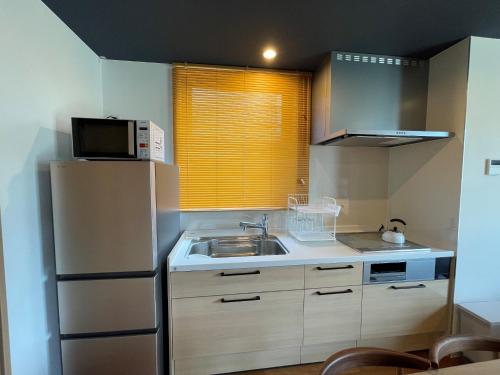 una pequeña cocina con fregadero y nevera. en THE VIEW Odawara shiro-no mieru hotel - Vacation STAY 67008v en Odawara