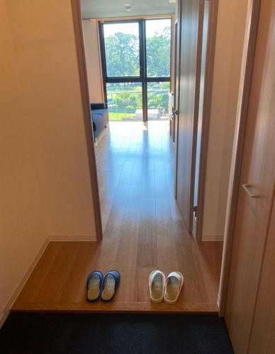 due paia di scarpe sul pavimento in un corridoio di THE VIEW Odawara shiro-no mieru hotel - Vacation STAY 67008v a Odawara