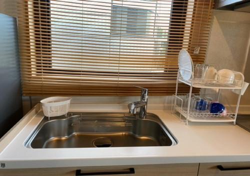 um balcão de cozinha com um lavatório e uma janela em THE VIEW Odawara shiro-no mieru hotel - Vacation STAY 67008v em Odawara