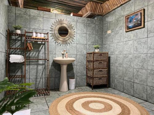 ein Bad mit einem Waschbecken und einem Spiegel in der Unterkunft Balay Lucia- BalayByTheSea serene villa near Vigan in San Juan
