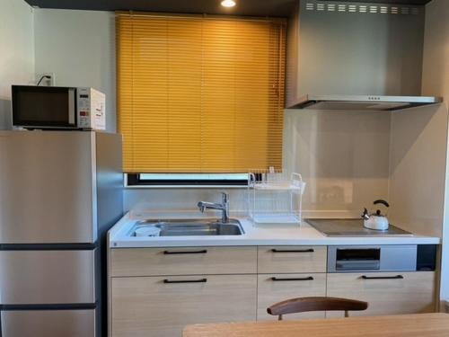 uma cozinha com um frigorífico de aço inoxidável e um lavatório em THE VIEW Odawara shiro-no mieru hotel - Vacation STAY 66089v em Odawara