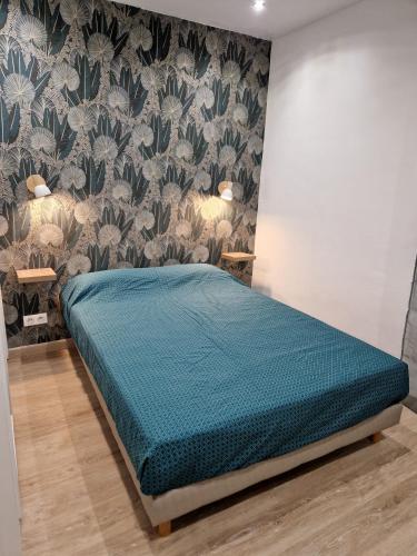 une chambre avec un lit avec une couette bleue dans l'établissement Appartement Ajaccio Climatisé 4 Personnes parking gratuit, à Ajaccio